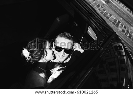 Look from above at bride and groom kissing in the car