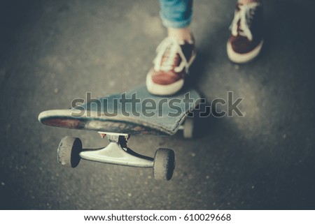 Young girl is holding her skateboard. Toned picture