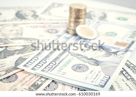 Multiple scattered American 100 dollar banknotes in full frame coverage with corner vignetting viewed from above in a conceptual financial background