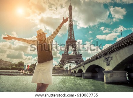 Woman tourist selfie near the Eiffel tower in Paris under sunlight and blue sky. Famous popular touristic place in the world.