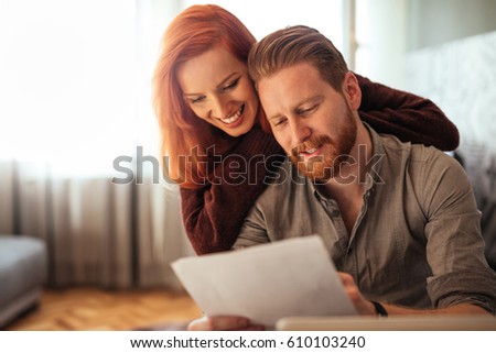 Photo of a happy couple doing finances at home.