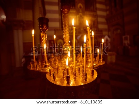 A lot of burning candles with shallow depth of field in the orthodox church, religion concept