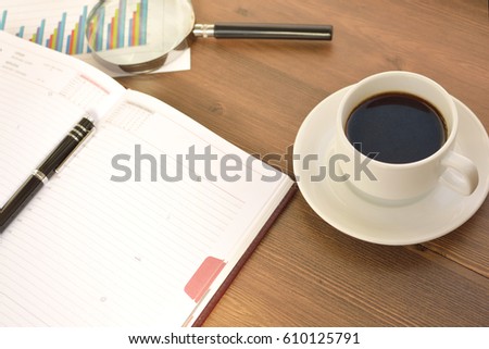 
Financial documents, graphics, statistical calculations and a mug of coffee on a wooden background. Coffee time. 