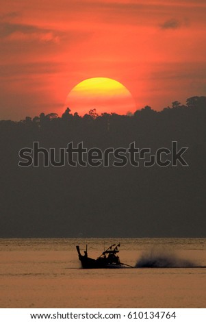 Fishing boat at sunset on ocean in Thailand