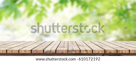 Empty wooden table with blurred green background with a country outdoor theme / Template mock up for display of product Royalty-Free Stock Photo #610172192