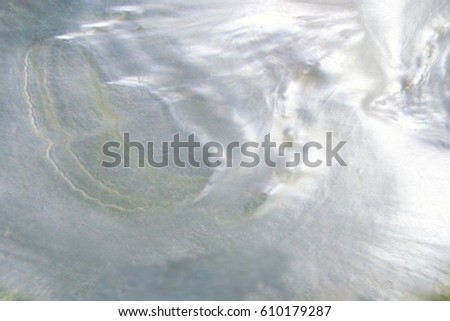 Abstract pearl background with lustrous nacre mother of pearl cloud blur with azure colours Royalty-Free Stock Photo #610179287