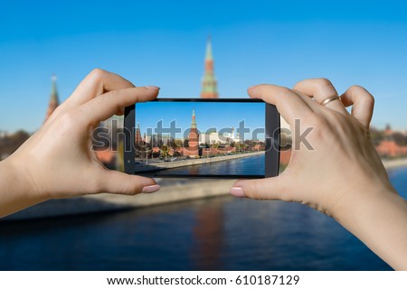 Hands holding smartphone photographing  Kremlin and Moskva riverbank in Moscow