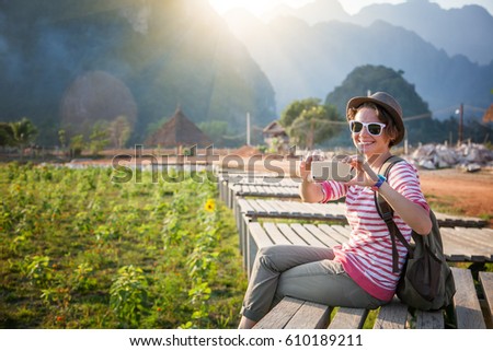 beautiful young woman takes the traveler on a mobile phone landscape. Travel to Asia