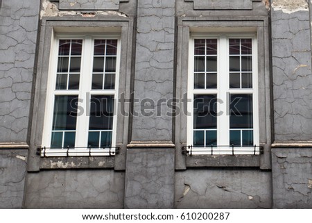 Vintage design windows on the facade of the ragged old house
