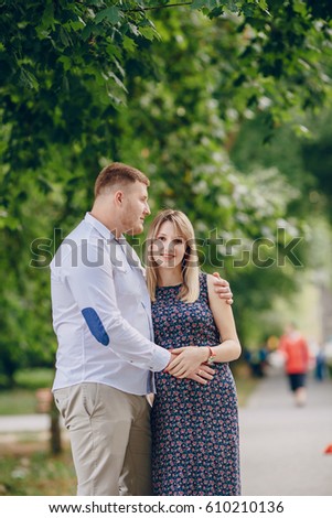 man with a pregnant wife walking in summer park