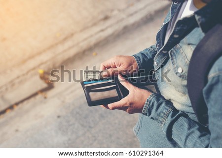 Hipster man hands holding wallet with credit cards and stack of money. Royalty-Free Stock Photo #610291364