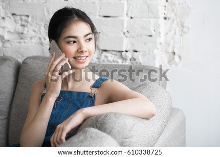 Young asian girl with mobile phone home.