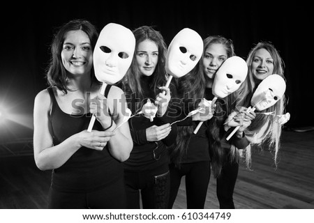 Drama on stage in theater. theater group on stage. Masks on stage in theater. Actress girls with masks. Royalty-Free Stock Photo #610344749