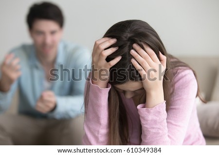 Sad lady holding hands on head thinking of divorce, unhappy couple arguing, upset woman tired of constant conflicts, addicted partner, bad relationships, frustrated girl ignoring boyfriend in anger  Royalty-Free Stock Photo #610349384