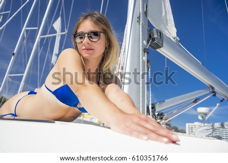 Woman in bikini on a sailboat sunbathing