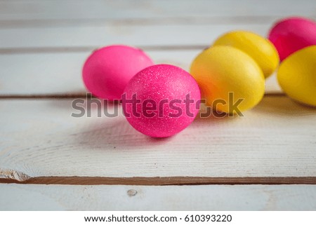 Easter background with yellow and pink eggs . Top view with copy space . Easter eggs on rustic wooden planks