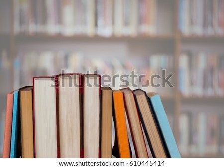 Digital composite of Standing books against blurry bookshelf