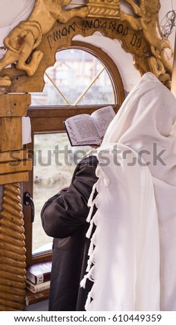 jewish prayer with tallit and tefillin Royalty-Free Stock Photo #610449359