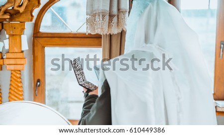 jewish prayer with tallit and tefillin Royalty-Free Stock Photo #610449386