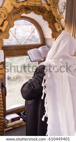 jewish prayer with tallit and tefillin Royalty-Free Stock Photo #610449401