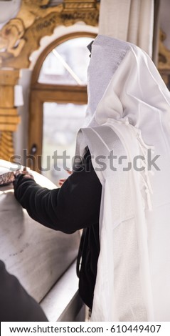 jewish prayer with tallit and tefillin Royalty-Free Stock Photo #610449407
