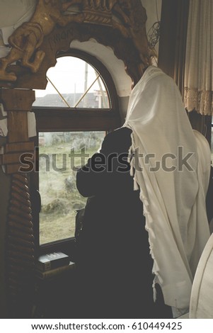 jewish prayer with tallit and tefillin Royalty-Free Stock Photo #610449425