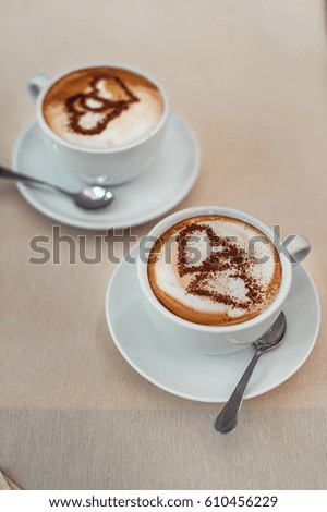 white Coffee cup with milk and two heart shape. soft light