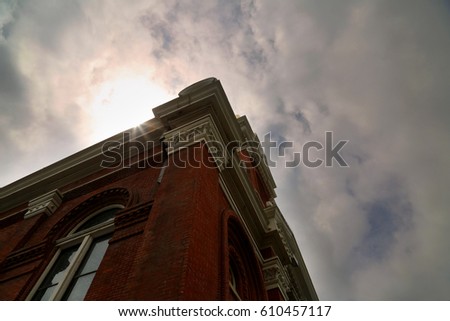 Authentic Catholic Church red brick building with sun and clouds blue sky