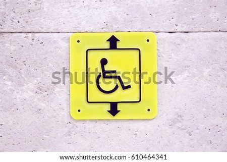 Yellow sign on wall lift for disabled.