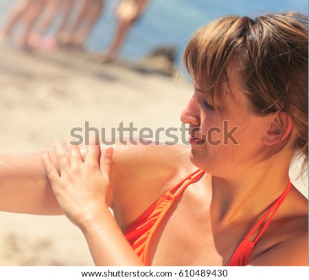 Young woman use sunscreen at beach