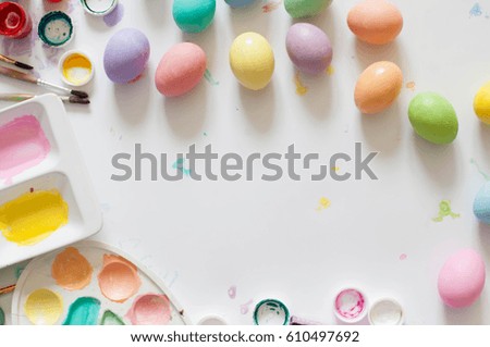 Colorful pastel easter eggs on wooden board background with space.