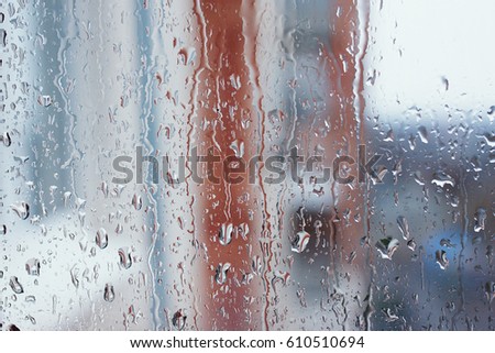 Window glass with increased condensation level, strong, high humidity in the room, large drops of water flow down the window, natural drops of water on the window glass, textures of water droplets 