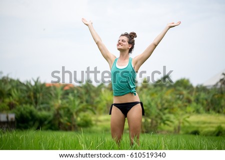 Happy Woman Exercising and Raising Hands on Meadow
