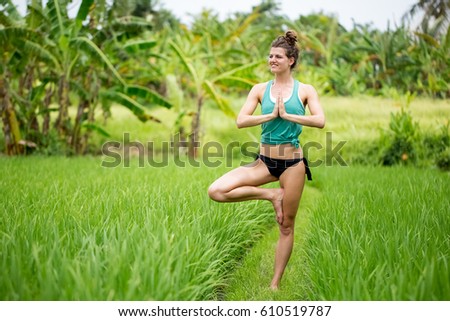 Peaceful Woman Standing in Tree Yoga Pose on Grass