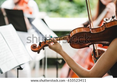 Woman plays the violin Royalty-Free Stock Photo #610523411