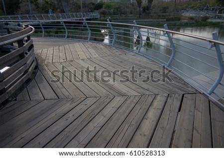 Wooden bridge in the park with metal railing
