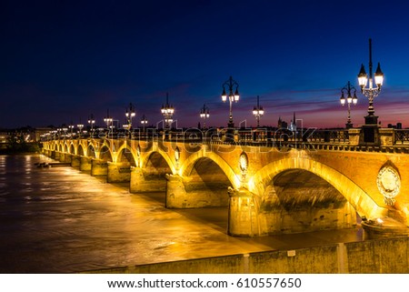 Pont de pierre, old stony bridge in Bordeaux in a beautiful summer night, France