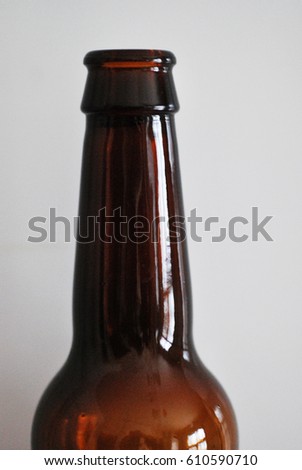 A closeup picture of a dark beer bottle neck