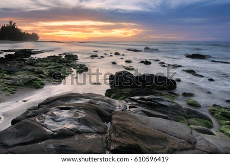 view of rocks covered by green moss during sunset at Kudat Sabah. Image contain soft focus and blur due to long exposure.