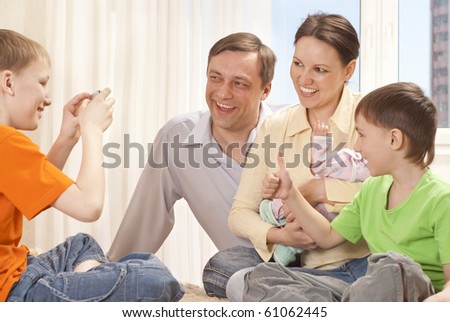 young boy photographing her happy family