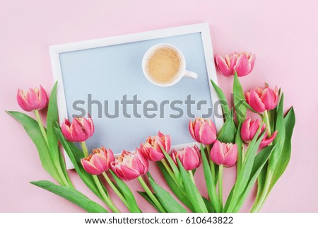 Beautiful breakfast with cup of coffee, spring tulip flowers and frame for good morning on pink pastel table top view in flat lay style