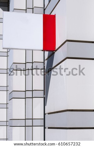 vertical side view of empty white square signage on the exterior of a building
