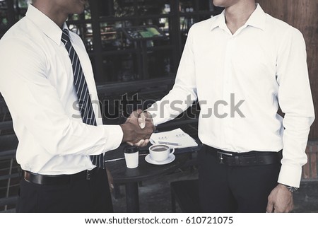 business partners handshaking after business success negotiation at coffee cafe

