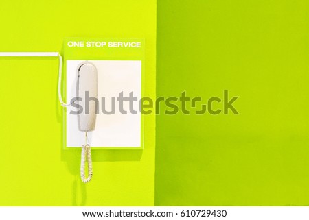 Telephone for help customer on the green wall and copy space - one stop service of concept