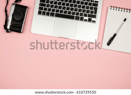 Flat lay photo of home office desk with laptop, notebook and camera. Colored background