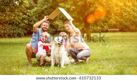 Family with roof over their heads as house construction goal concept Royalty-Free Stock Photo #610732133