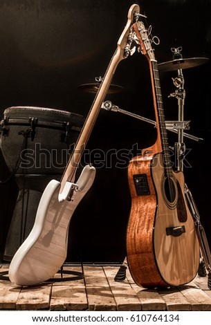 musical instruments, acoustic guitar and bass guitar and percussion instruments drums on a black background, the music concept