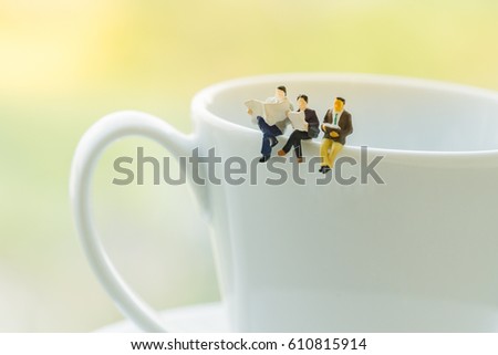 Miniature people: small figures toy Business People sitting and discuss about business deal on coffee cup, Relaxing and business  concept