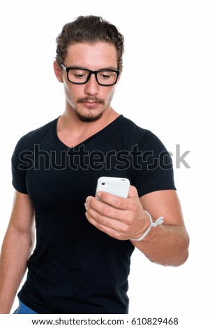 Studio shot of young handsome man using mobile phone with eyeglasses isolated against white background