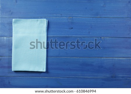Wooden picnic table with blue dishcloth on.